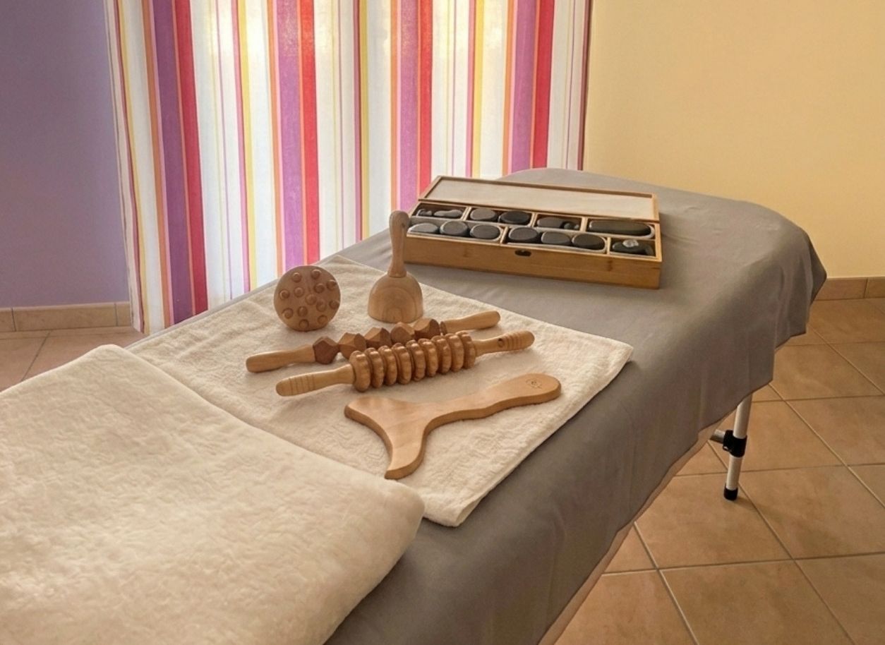 La salle de massage du cabinet, table préparée avec pierres chaudes et outils en bois